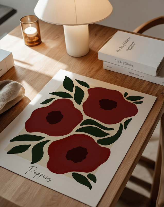 Floral artwork with red poppies on a wooden table.
