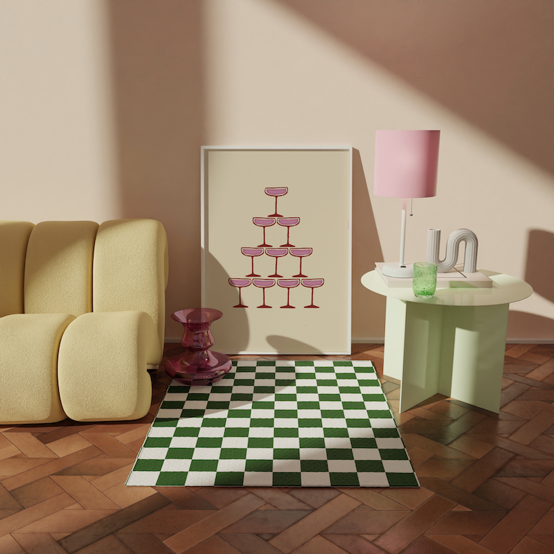 A framed print featuring a pink champagne fountain leaning against a wall surrounded by eclectic colourful decor