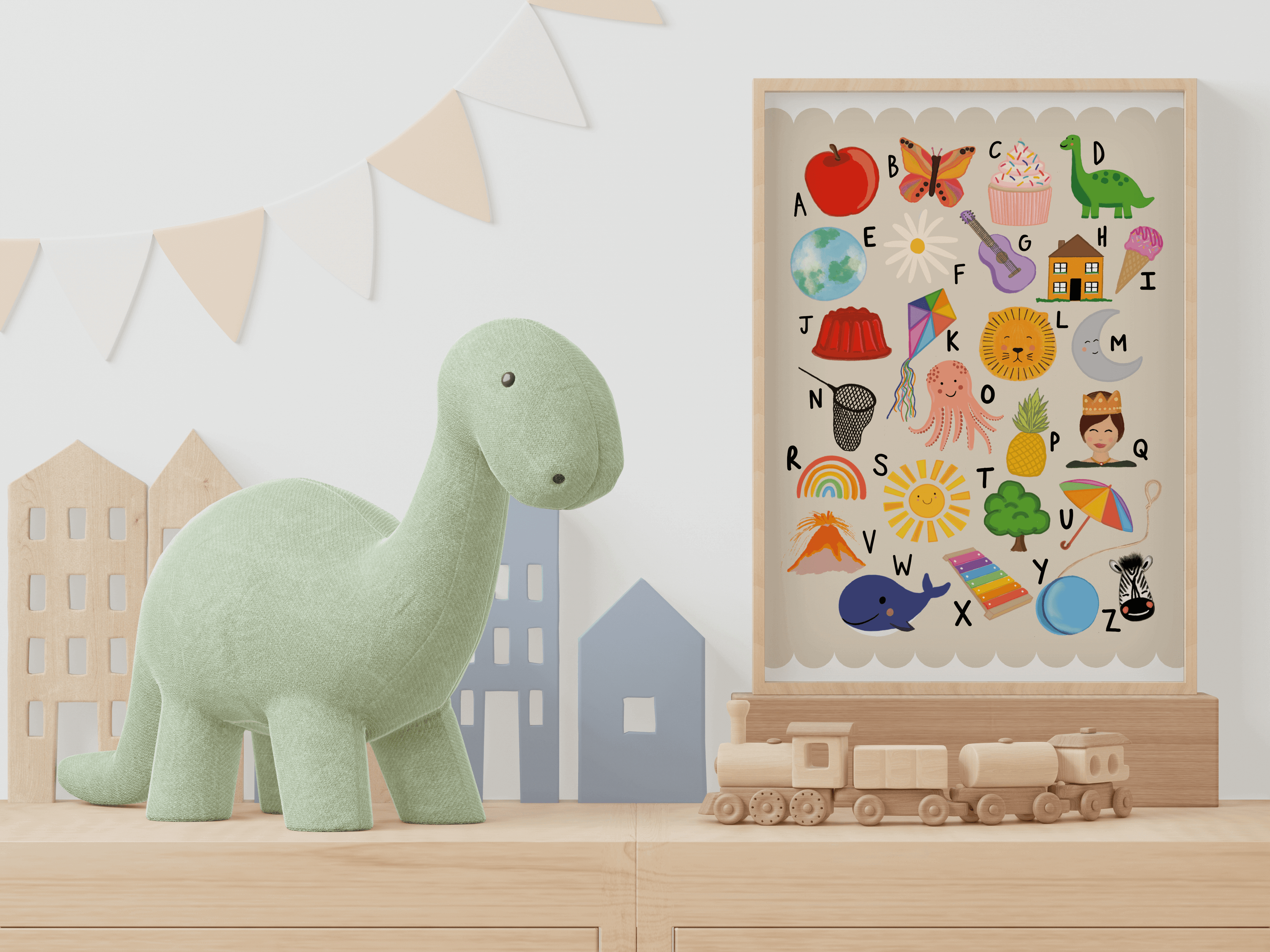 Children's educational print showing alphabet and related illustrations with scallop border with beige background. Print is displayed in wooden frame alongside children's decorative items and toys.