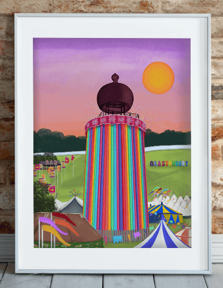 Art print featuring Glastonbury Festival's iconic ribbon tower in vibrant colours, displayed in a white frame leaning against a brick wall.