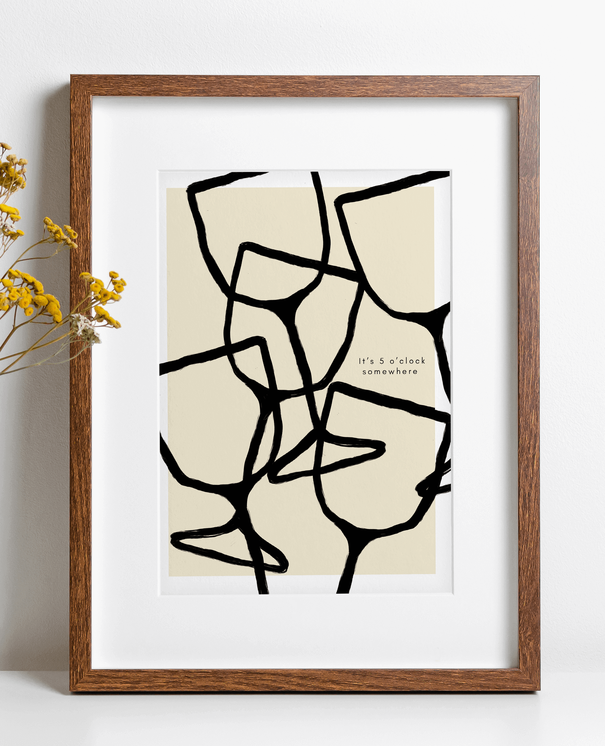 Art print features black line art illustrations of wine glass in a repeat pattern alongside typography "it's 5 o'clock somewhere" against neutral background with white border. Print is displayed in wooden frame.