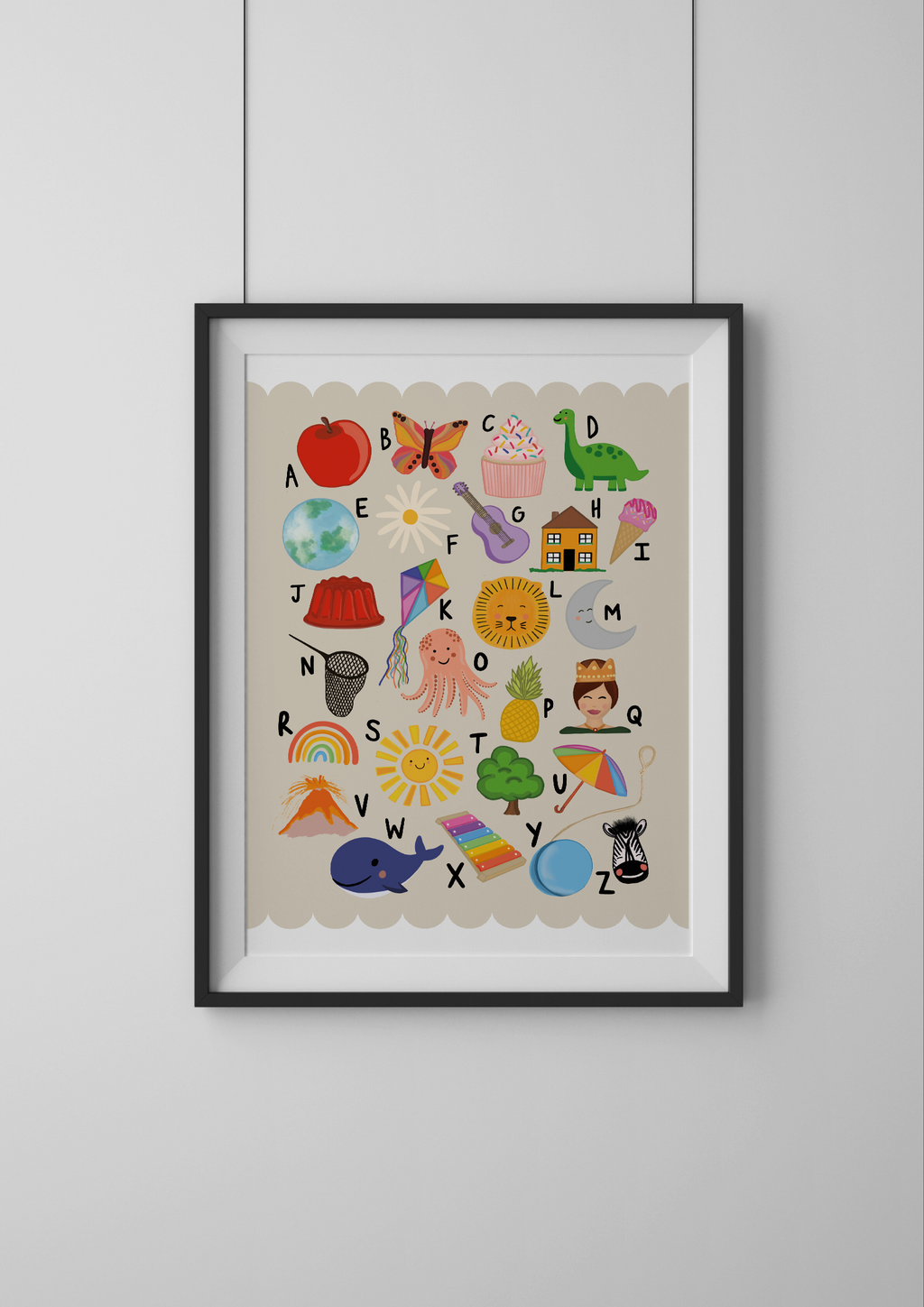 Framed alphabet poster with colorful illustrations on a white wall