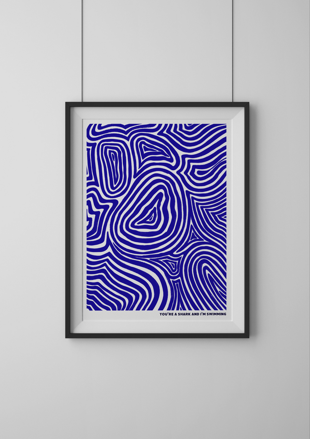 Framed abstract art print with blue wavy pattern on a white wall