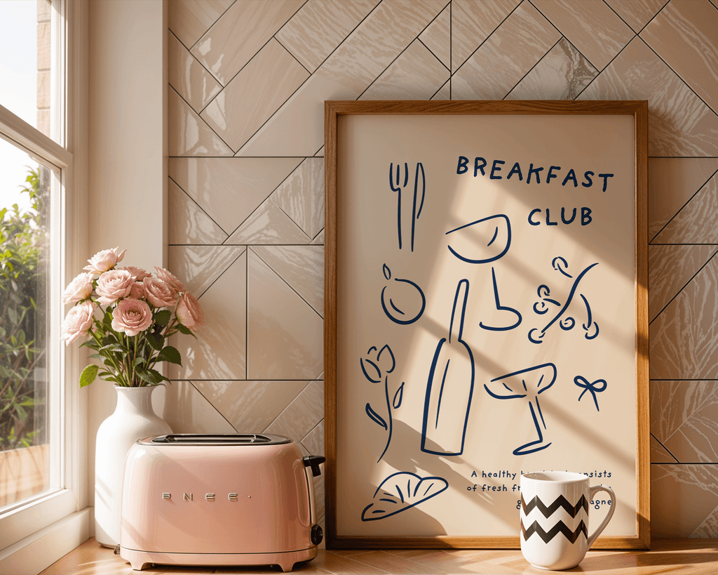 Kitchen scene with a pink toaster, vase of flowers, and framed artwork titled 'Breakfast Club'.