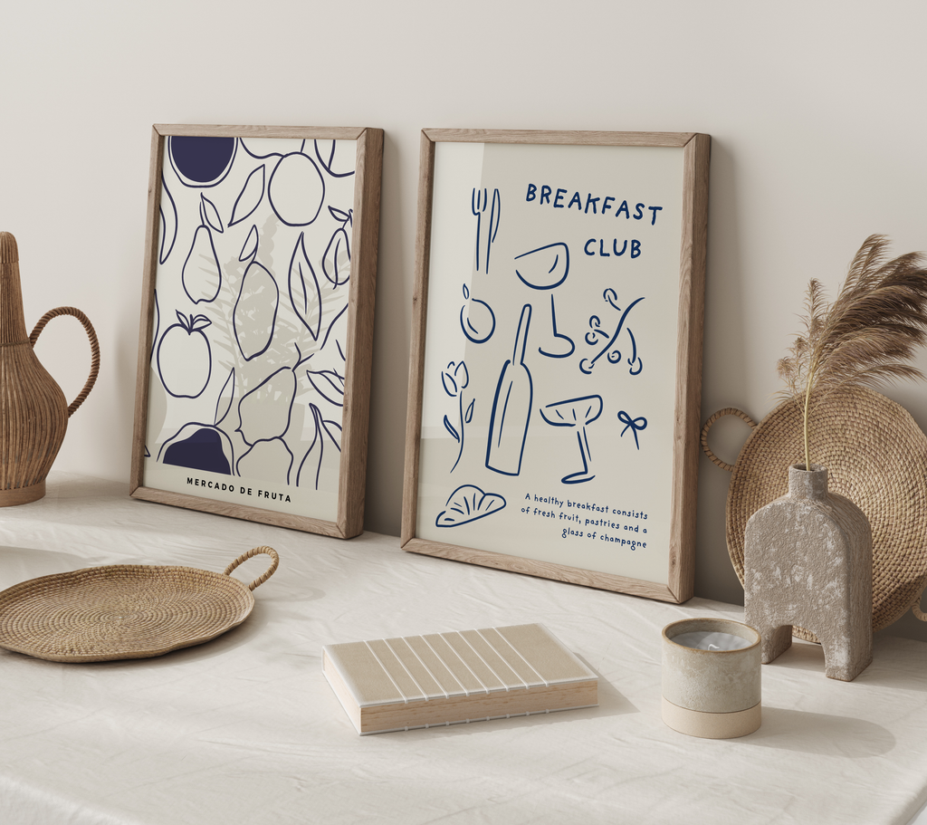 Two framed prints on a table with decorative items