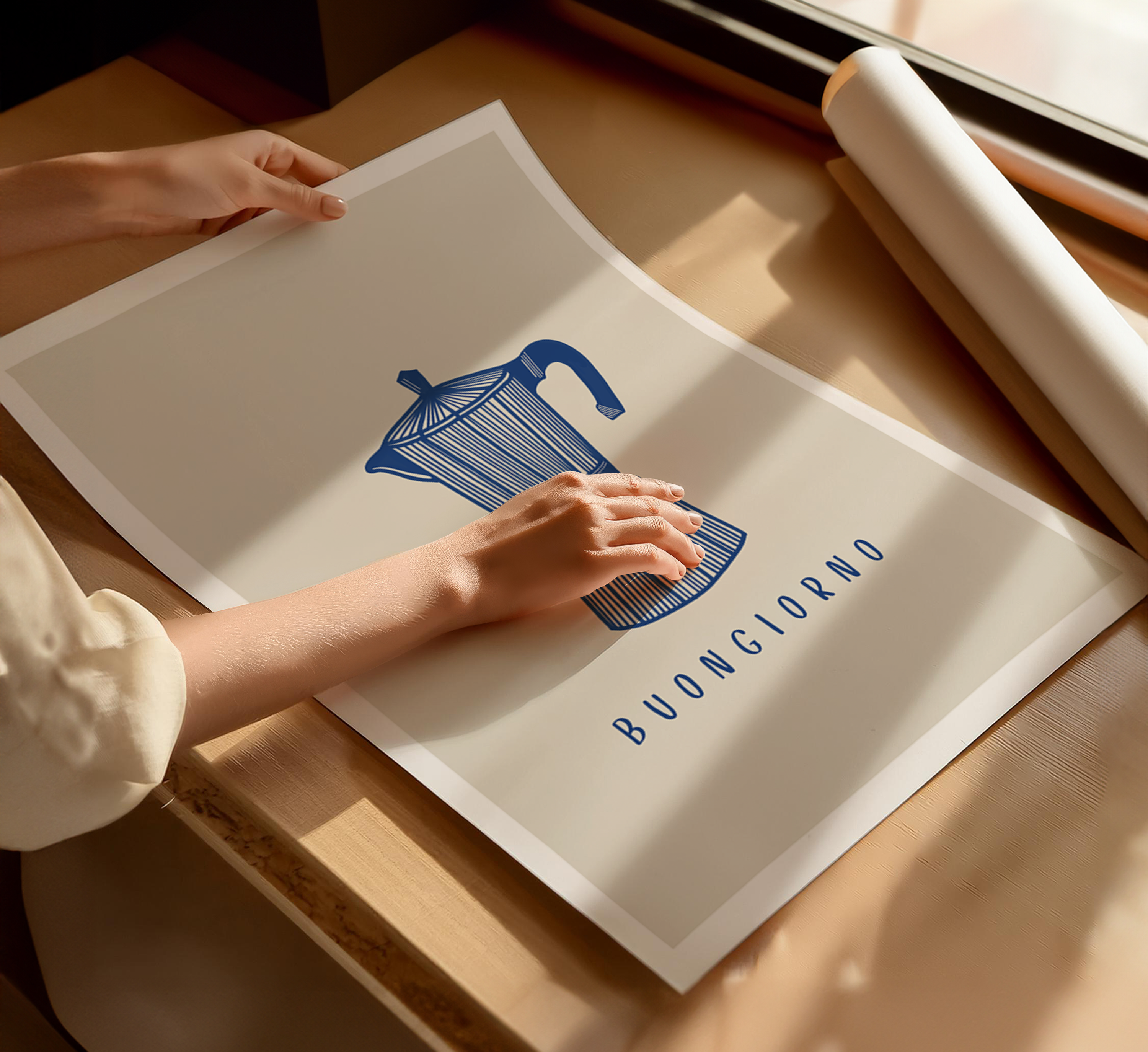 Italian coffee art print laying on table with neutral decor featuring moka pot illustration and "Buongiorno" typography, beige background and white border. A person is handling the print.