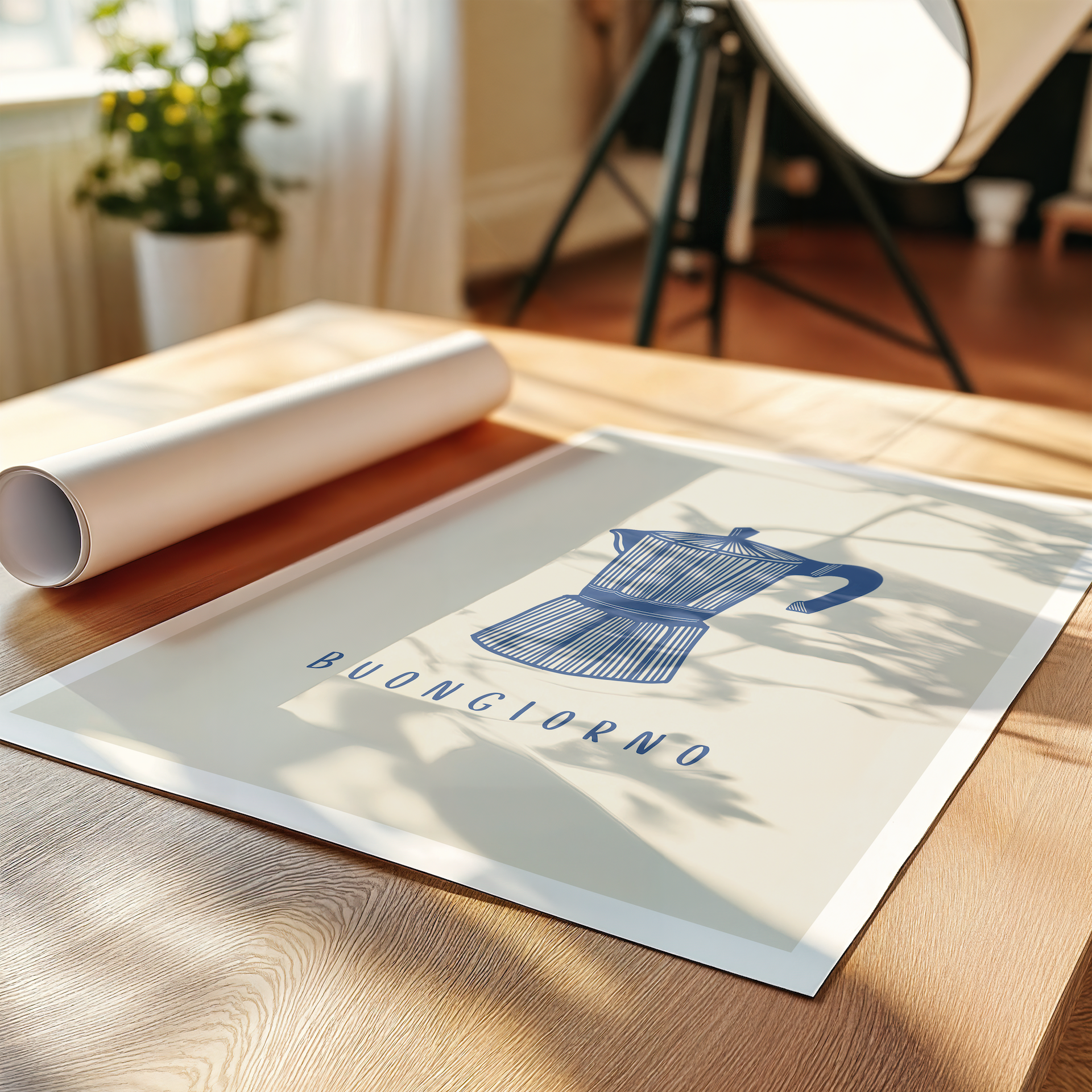 Italian coffee art print laying on table with neutral decor, plant and lamp, featuring moka pot illustration and "Buongiorno" typography, beige background and white border. 
