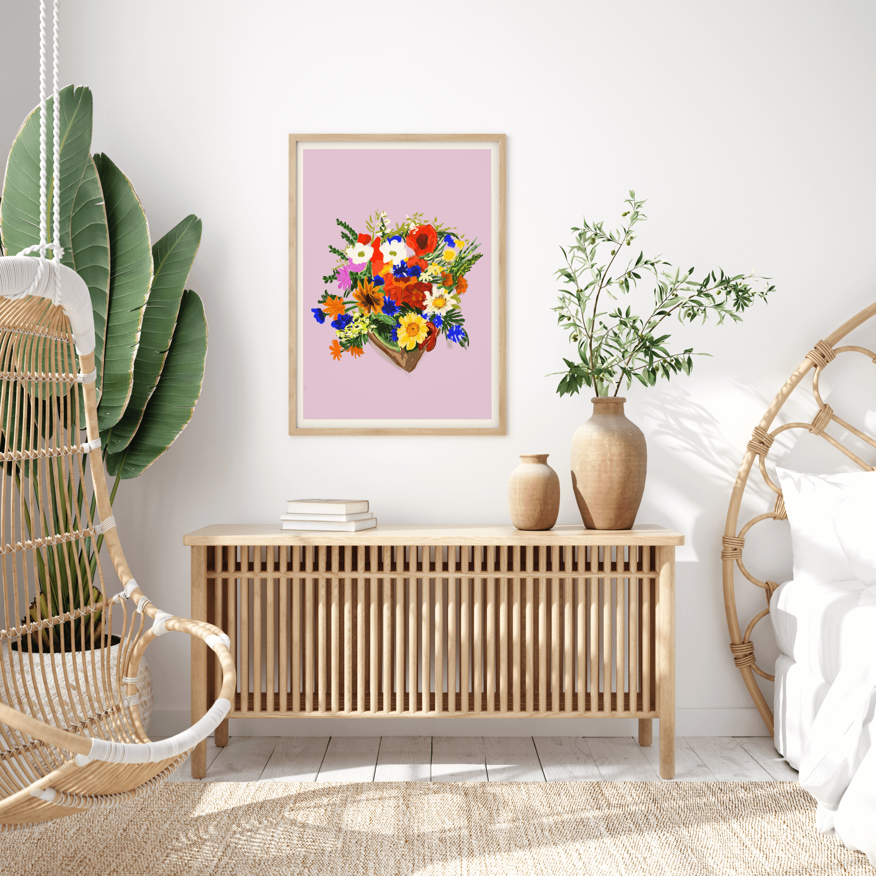 Print features a bouquet of colourful bouquet of flowers, against a dusty pink/lilac background with a small white border. The bouquet features yellows, blues, reds, whites and green foliage. Print is displayed in a wall-hung frame surrounded by boho decor.