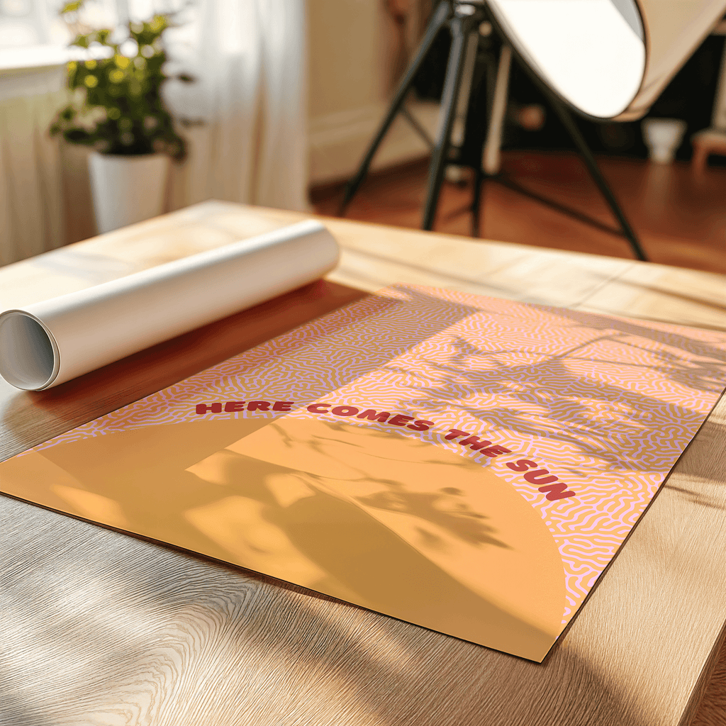 Here comes the sun music art print on a table surrounded by decorative plant and lamp.