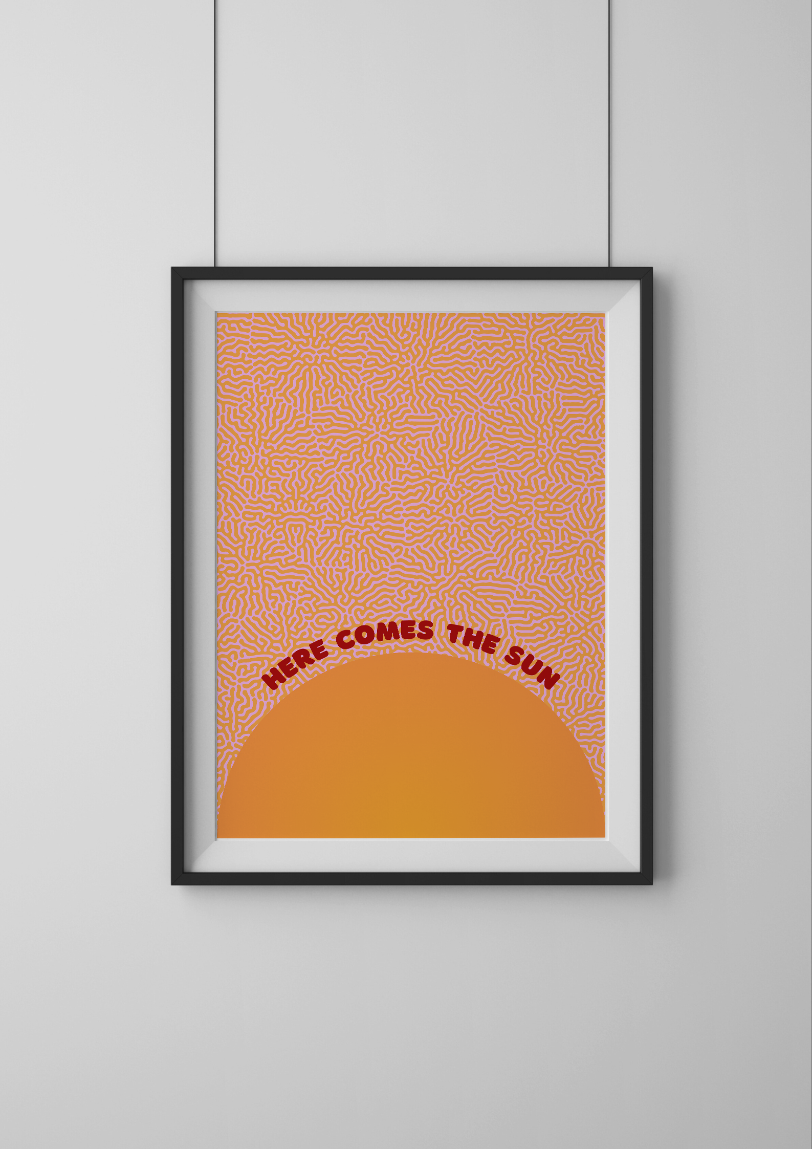 Framed artwork with a geometric pattern and text 'Here Comes the Sun' on an orange background.