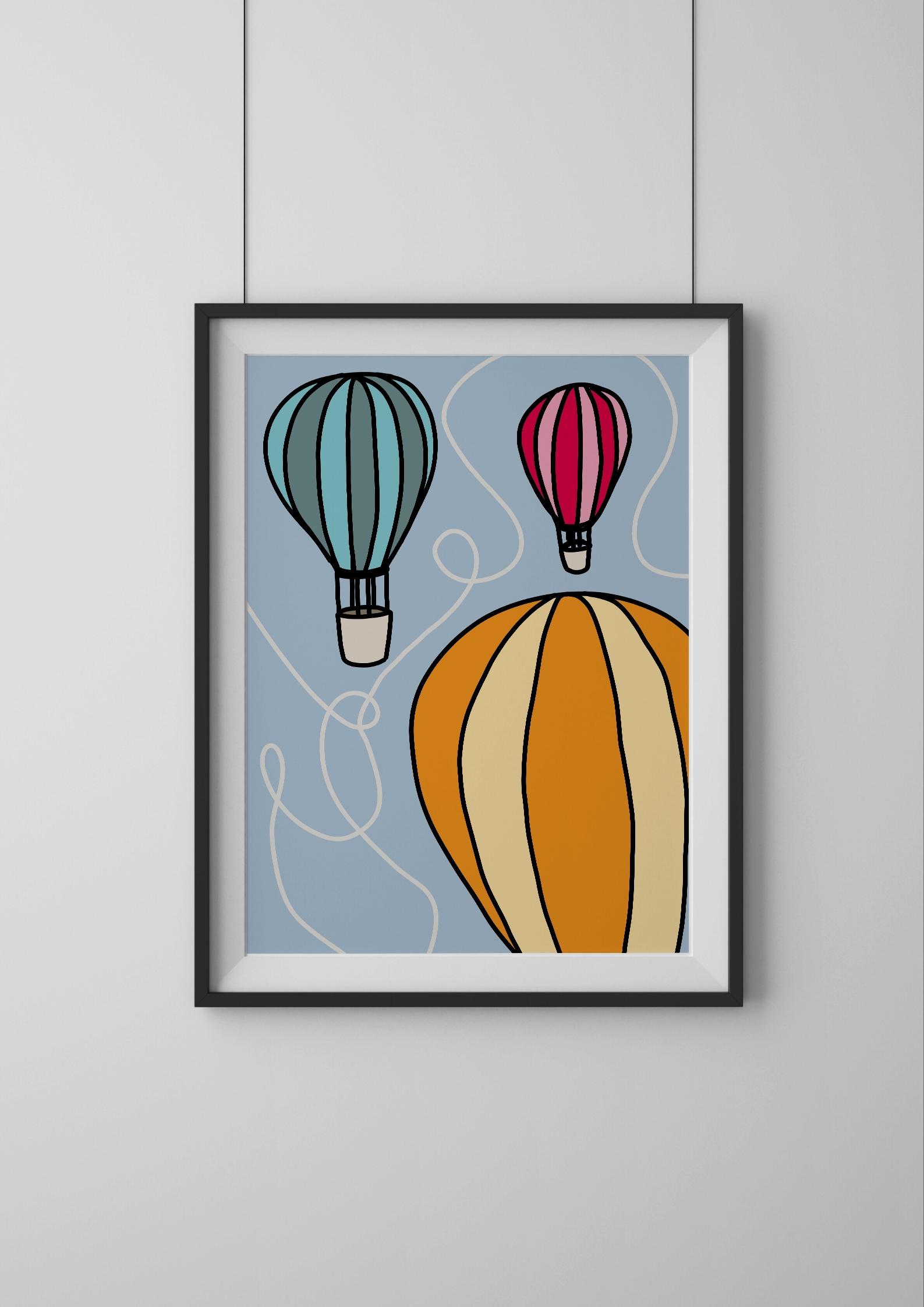 Framed artwork of colorful hot air balloons on a light gray wall.