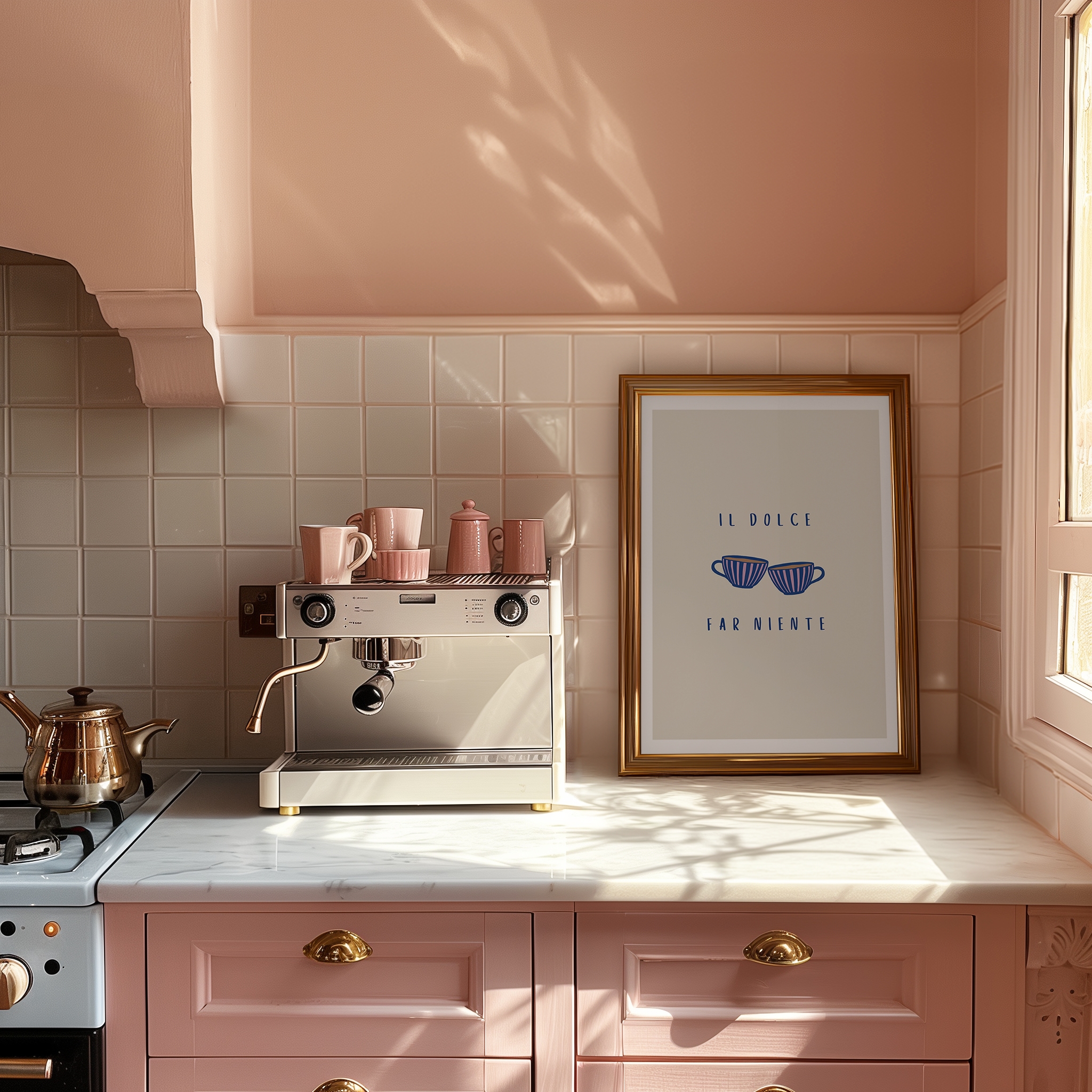 A pink kitchen with coffee machine and pink crockery, with a framed art print featuring two coffee cups and Italian typography "Il dolce far niente" against beige background with white border.