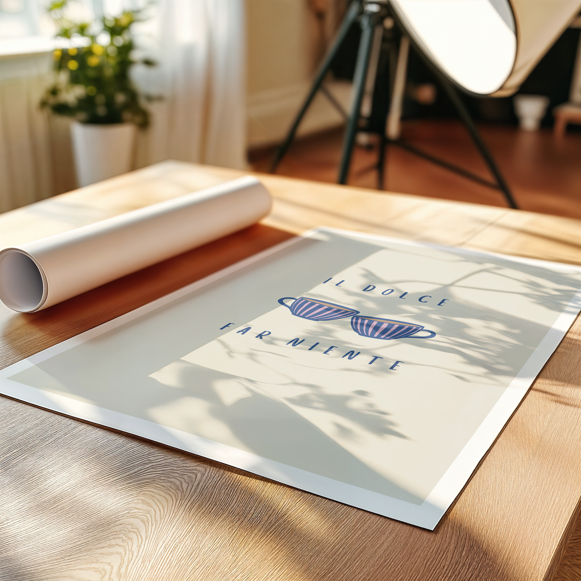 An art print laying on a table featuring Italian typography "il dolce far niente" and two coffee cups in a room with decorative plant and lamp