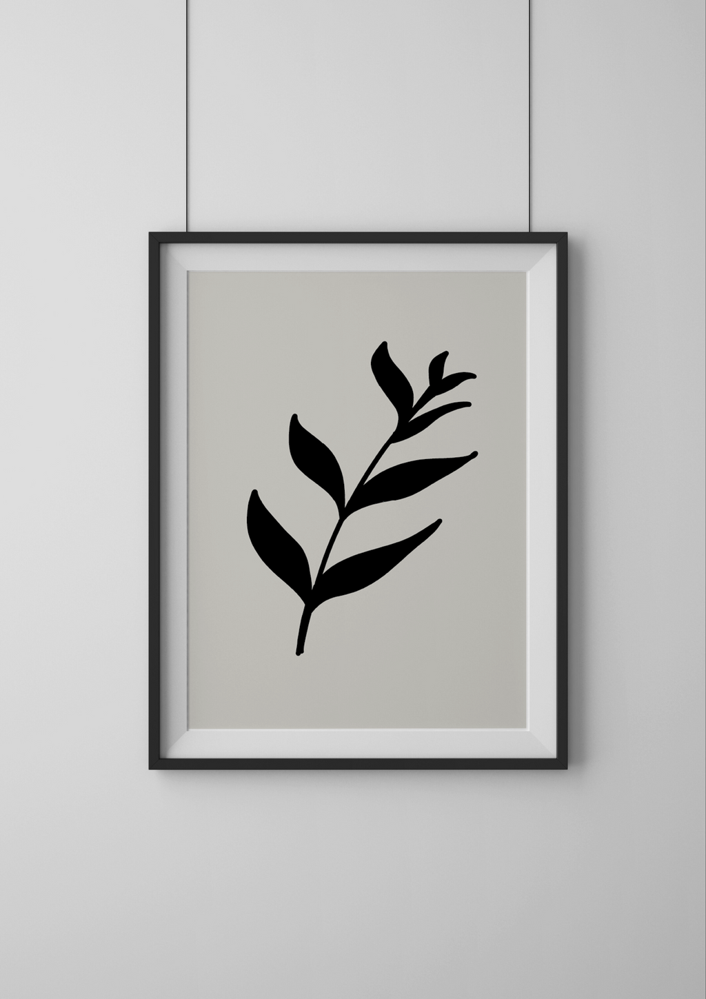 Framed artwork with a black leaf design on a light gray background