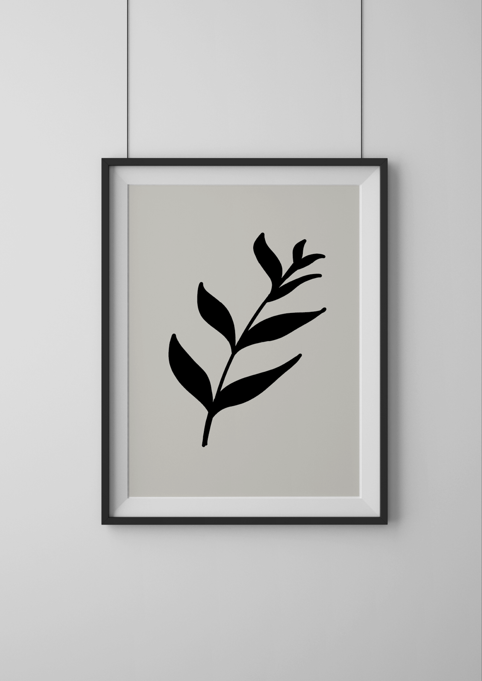Framed artwork with a black leaf design on a light gray background