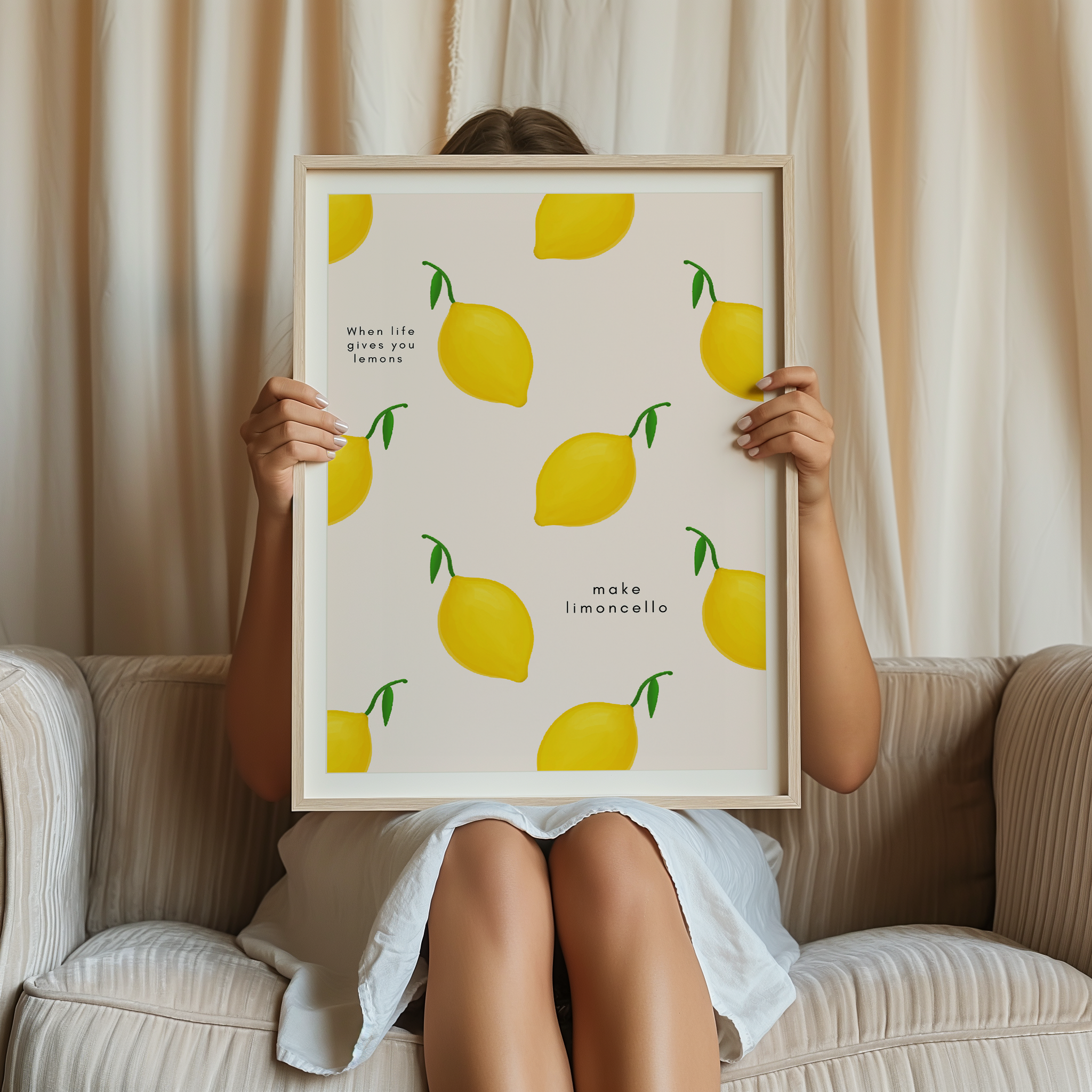 Person holding a framed print with lemon pattern and text.