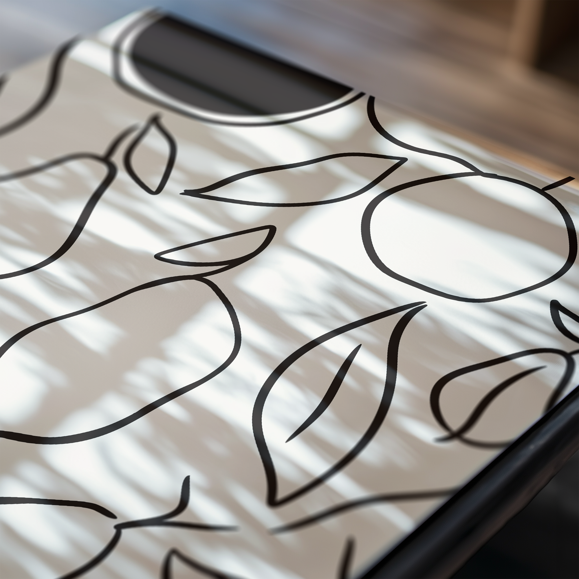 Close-up of a white surface with black leaf patterns