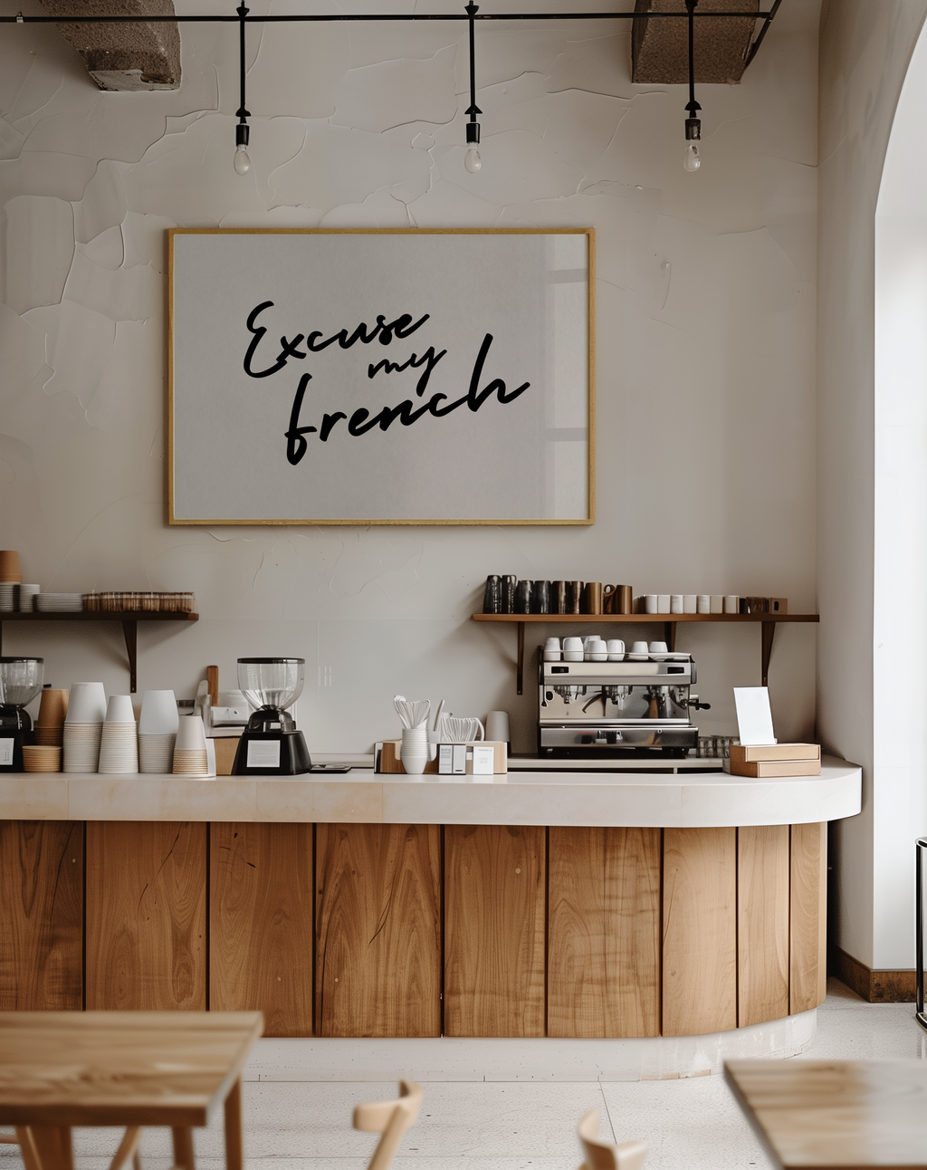 Coffee shop interior with a sign reading 'Excuse my French' on the wall.