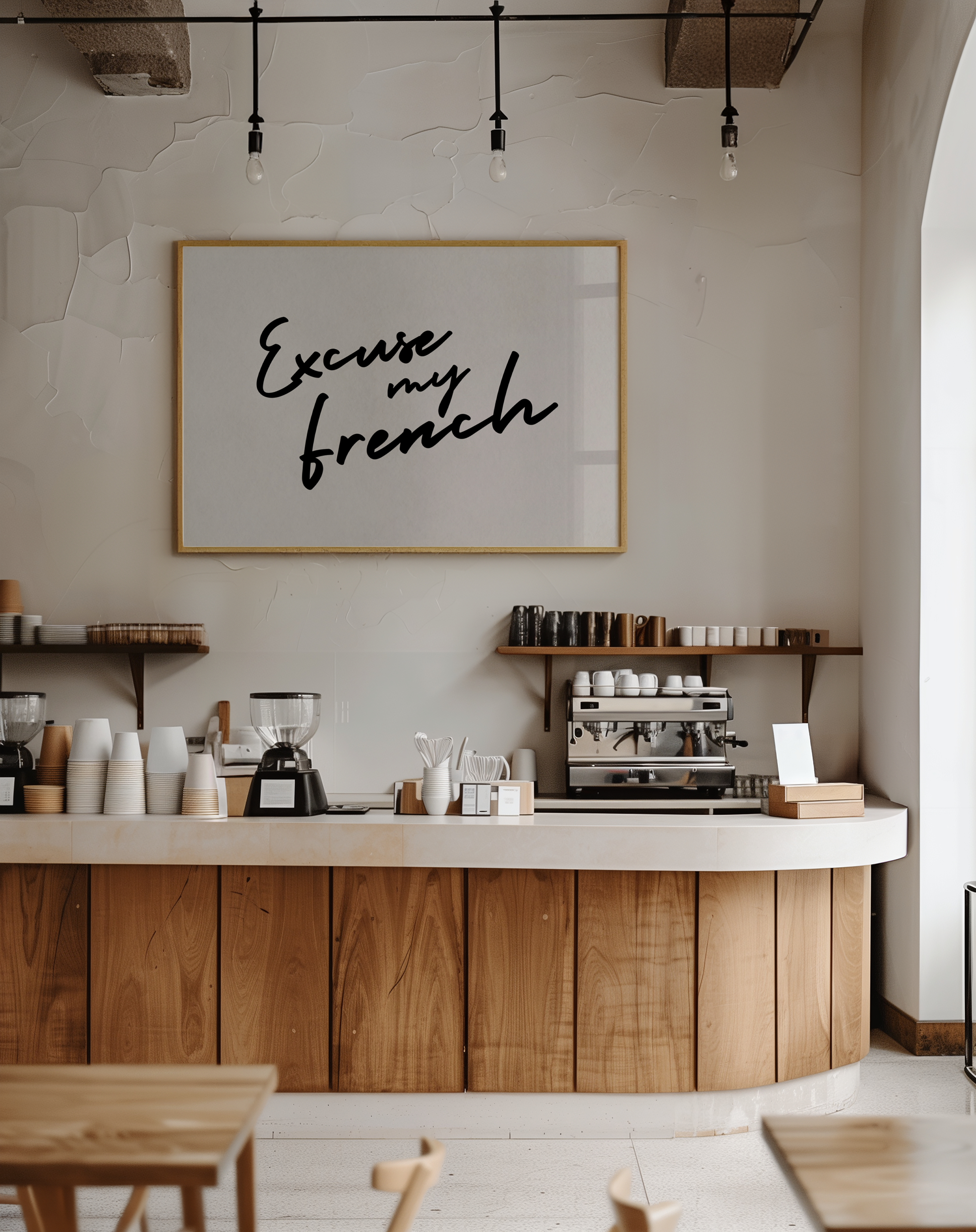 Coffee shop interior with a sign reading 'Excuse my French' on the wall.