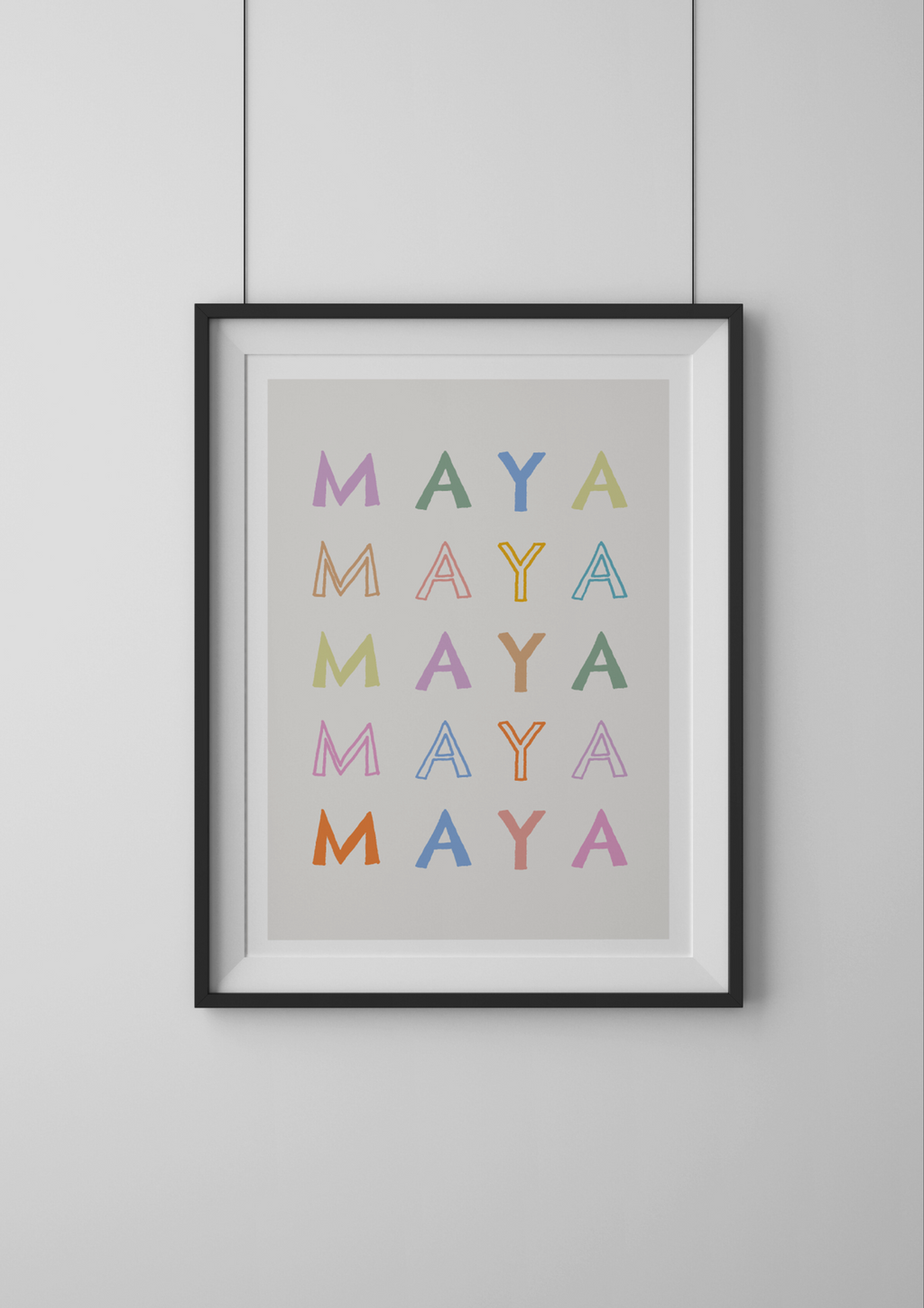 Framed artwork with 'MAYA' repeated in various colors on a gray background
