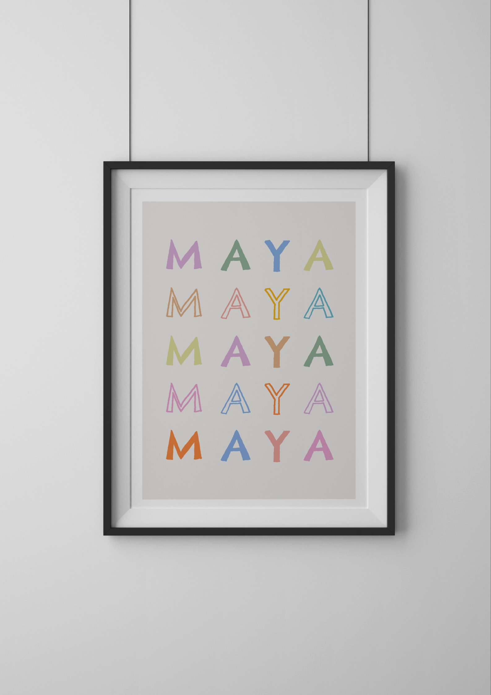 Framed artwork with 'MAYA' repeated in various colors on a gray background