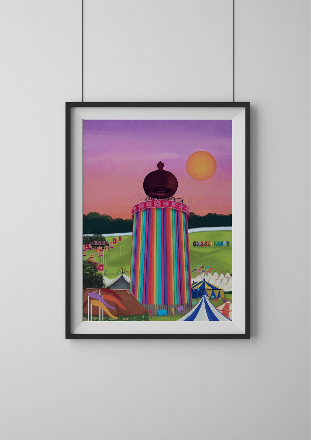 Framed artwork of a colorful striped ribbon tower against a pink sunset sky.