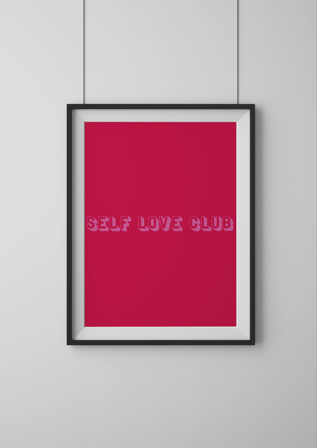 Framed poster with 'SELF LOVE CLUB' text on a red background, mounted on a light gray wall.