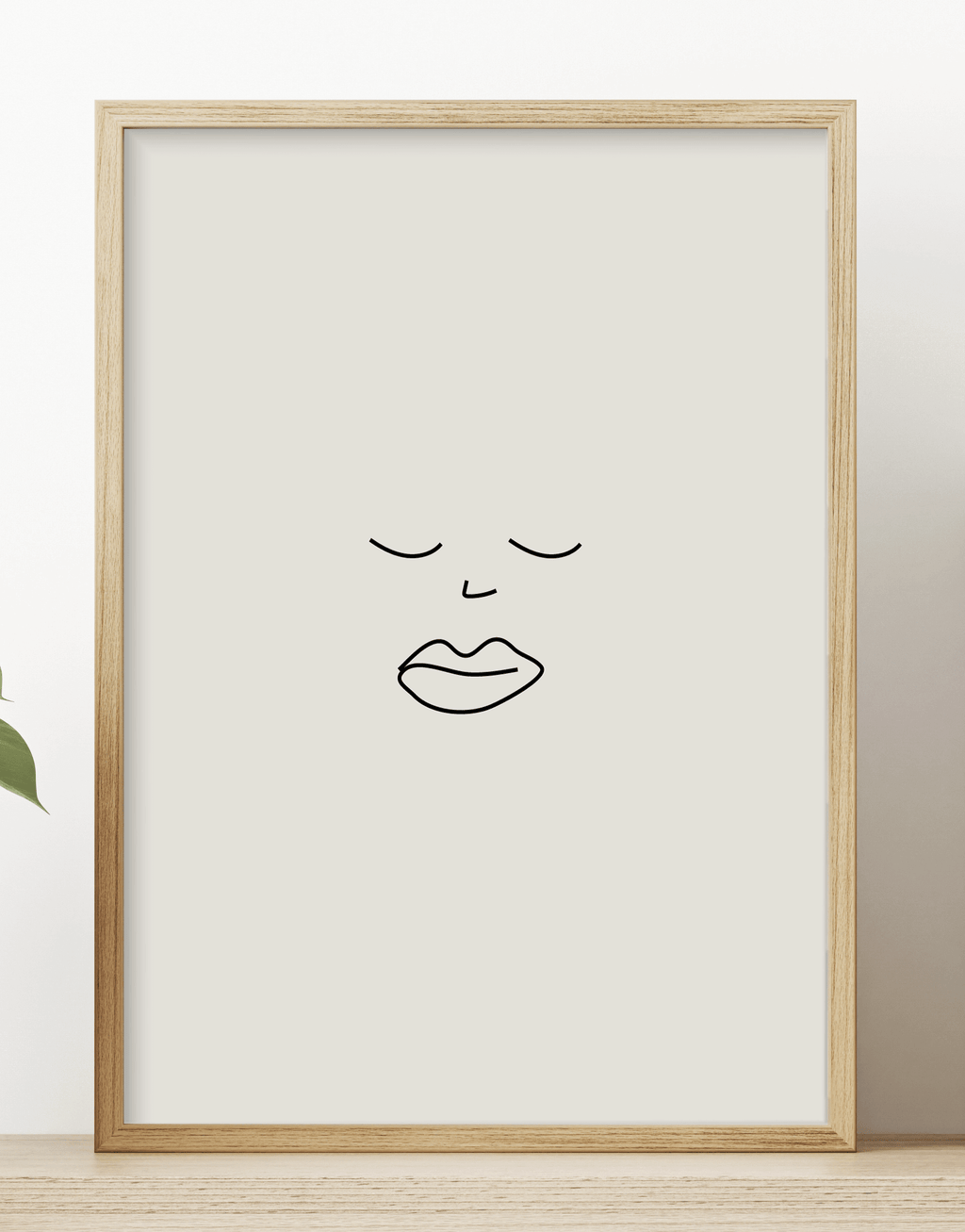 Minimalist line print featuring a black illustration of a face, displayed in a wooden frame