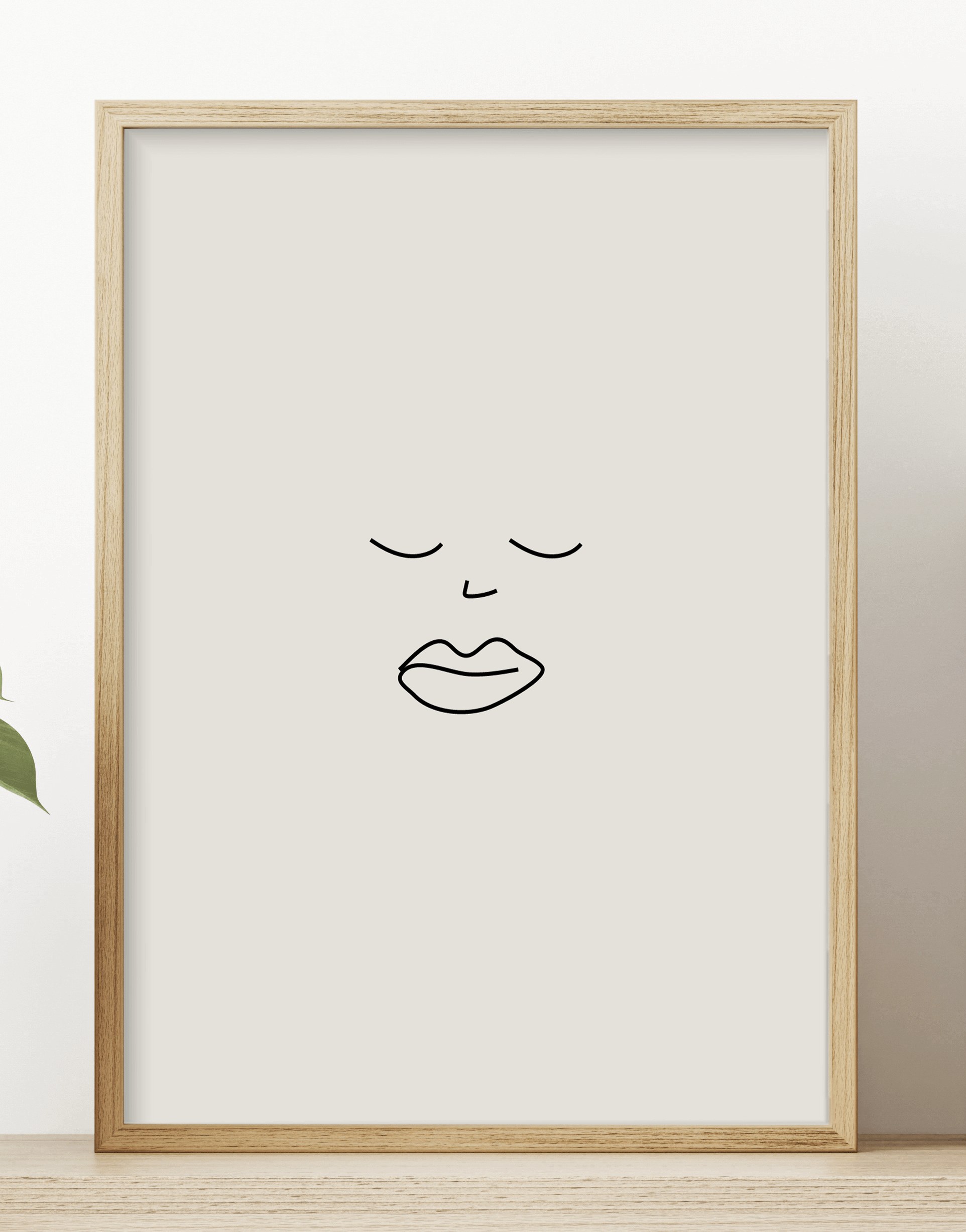 Minimalist line print featuring a black illustration of a face, displayed in a wooden frame